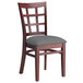 A Lancaster Table & Seating mahogany wood window back chair with a dark gray vinyl seat.