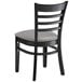 A Lancaster Table & Seating black wood restaurant chair with a light gray vinyl seat.