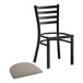 A Lancaster Table & Seating black ladder back chair with a dark gray vinyl padded seat.