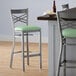 A Lancaster Table & Seating cross back bar stool with a seafoam green vinyl padded seat and back.
