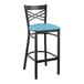 A Lancaster Table & Seating black cross back bar stool with a blue vinyl padded seat.