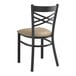 A black Lancaster Table & Seating metal cross back chair with a taupe vinyl cushion.