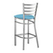 A Lancaster Table & Seating metal ladder back bar stool with a blue vinyl padded seat.