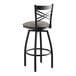 A Lancaster Table & Seating black cross back swivel bar stool with a dark gray cushion.