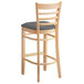 A Lancaster Table & Seating wooden ladder back bar stool with a dark gray vinyl seat.