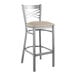 A Lancaster Table & Seating metal cross back bar stool with a light gray cushion on the seat.