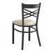 A black metal Lancaster Table & Seating cross back restaurant chair with a light gray cushion.