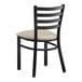 A black Lancaster Table & Seating ladder back chair with a light gray cushion.