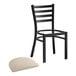 A Lancaster Table & Seating black ladder back chair with a light gray cushion