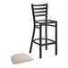 A black Lancaster Table & Seating ladder back bar stool with a light gray cushion on the seat.