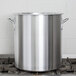 A Vollrath 60 quart aluminum stock pot on a stove.