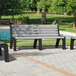 Three MasonWays gray plastic park benches with black legs on a brick patio.