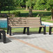 Three MasonWays Malibu-style park benches with black legs on a brick patio with grass.