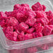 A plastic container of Dole IQF pink Pitaya chunks.