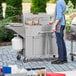 A man using a Backyard Pro double tank outdoor fryer to cook food outside