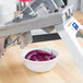 A Vollrath Onion King 3/8" pusher head assembly on a machine with a bowl of red onions.