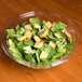 A salad with croutons in a clear Sabert plastic bowl.