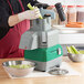 A person using an AvaMix commercial food processor to cut celery.