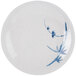 A white plate with blue painted bamboo leaves.