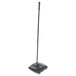 A black Rubbermaid Executive Series floor sweeper with a long handle.