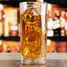 An Anchor Hocking highball glass filled with amber liquid and ice.
