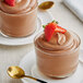 Two glasses of Callebaut dark chocolate mousse with strawberries on top.
