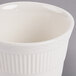 An Ivory china bouillon cup with an embossed rim and handle.
