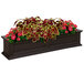 A Mayne Fairfield planter box with red and green flowers.