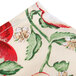 A white cloth with red apple print and leaves and flowers.