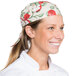 A woman wearing an apple patterned chef neckerchief at a professional kitchen counter.