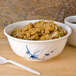 A bowl of rice with vegetables in a Thunder Group Blue Bamboo melamine bowl on a wooden surface.