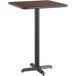 A Lancaster Table & Seating bar height table with a black metal base and a reversible cherry/black square top.