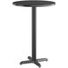 A black table with a tall metal base and a round top.