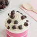 A cup of ice cream with brown pieces of chocolate on top using Double Chocolate Chip Cookie Dough Ice Cream Topping.