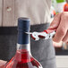 A person using an Acopa waiter's corkscrew to open a bottle of wine.