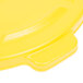 A yellow plastic lid with a handle for a Rubbermaid BRUTE trash can.