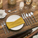 A table set with Acopa Hepburn steak knives, silverware, and napkins.