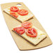 A rectangular flat bread serving board with a slice of bread with tomatoes on it.