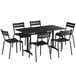 A Lancaster Table & Seating black outdoor dining set with six chairs on a table with an umbrella hole.