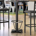 A Lancaster Table & Seating black bar height table with a foot ring.