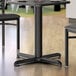 A Lancaster Table & Seating black table base with leveling feet.