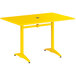 A yellow Lancaster Table & Seating aluminum table with a metal base.