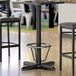 A Lancaster Table & Seating black bar height table base with a foot ring on a table.