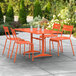 An orange table and chairs on an outdoor patio.