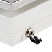 A white box with a stainless steel platform and black knob on a Edlund Digital Portion Scale.