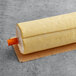 A White Toque traditional puff pastry roll with orange packaging on a table.