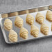 A baking sheet with six White Toque mini butter croissants.