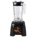 A black Waring X-Prep blender with a clear container on a counter.