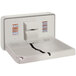 A white plastic surface mount baby changing station with a black strap.