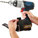 A person tethering a power tool using an Ergodyne Squids tethering kit.